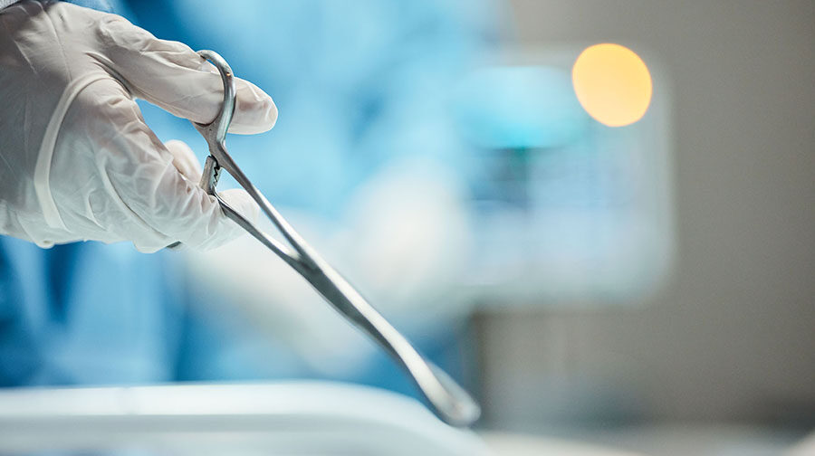 Closeup of surgical clamps in a surgeons hands during an operation