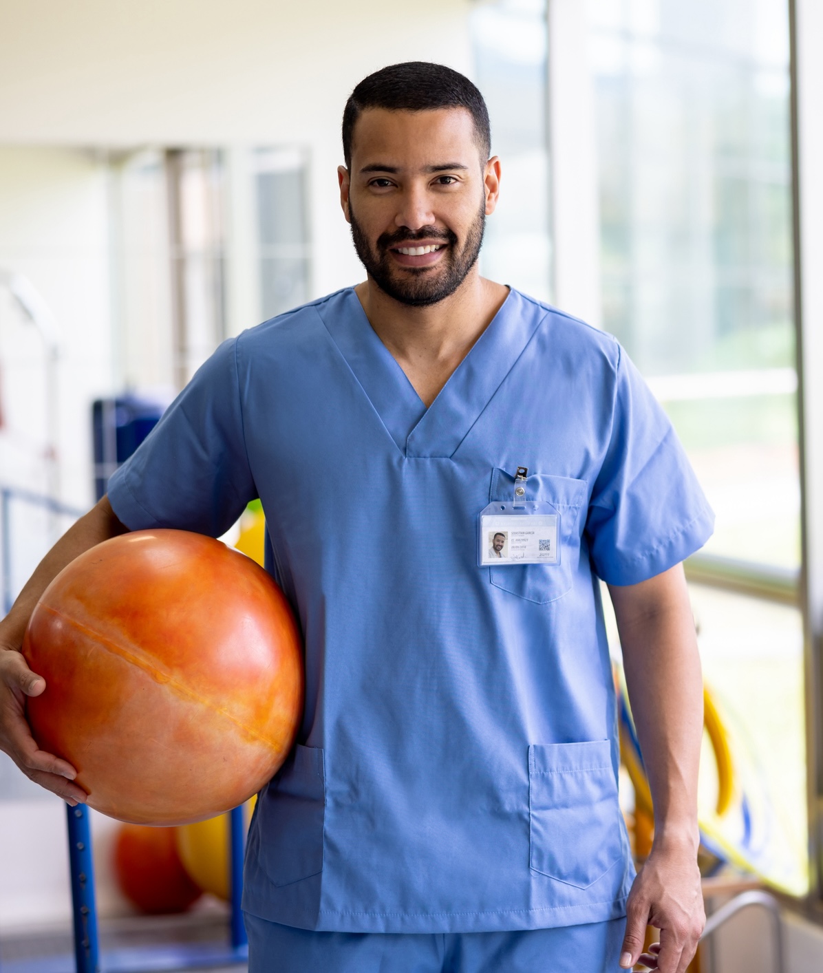 Physical therapist working at a rehabilitation center and holding a fitness ball